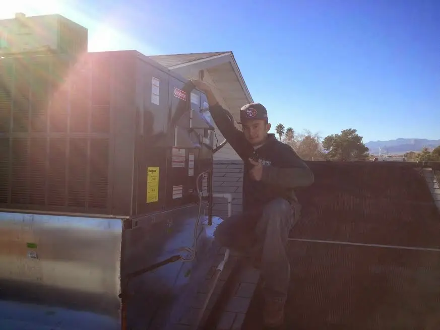 HVAC technician performing AC Tune-Up on a rooftop unit in East Manchester